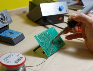 person soldering green circuit board thumbnail