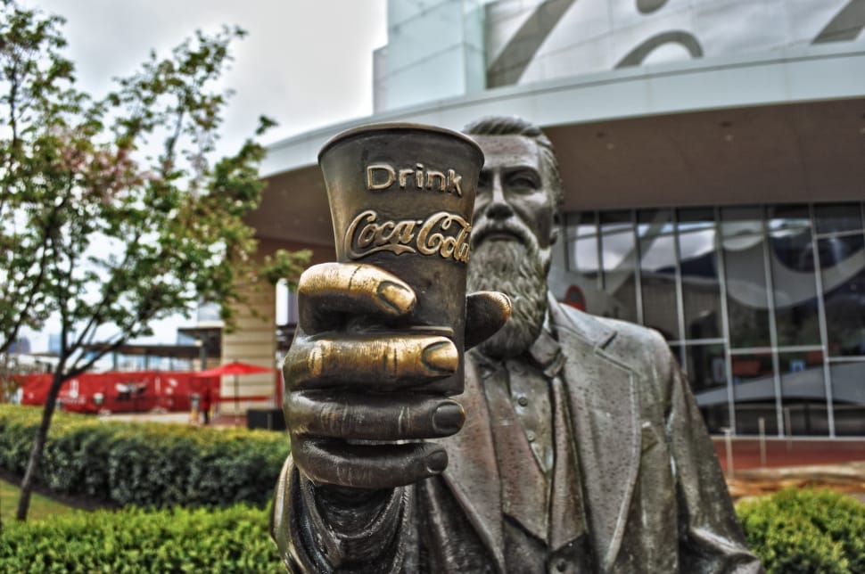 man holding drink coca cola cup statue preview