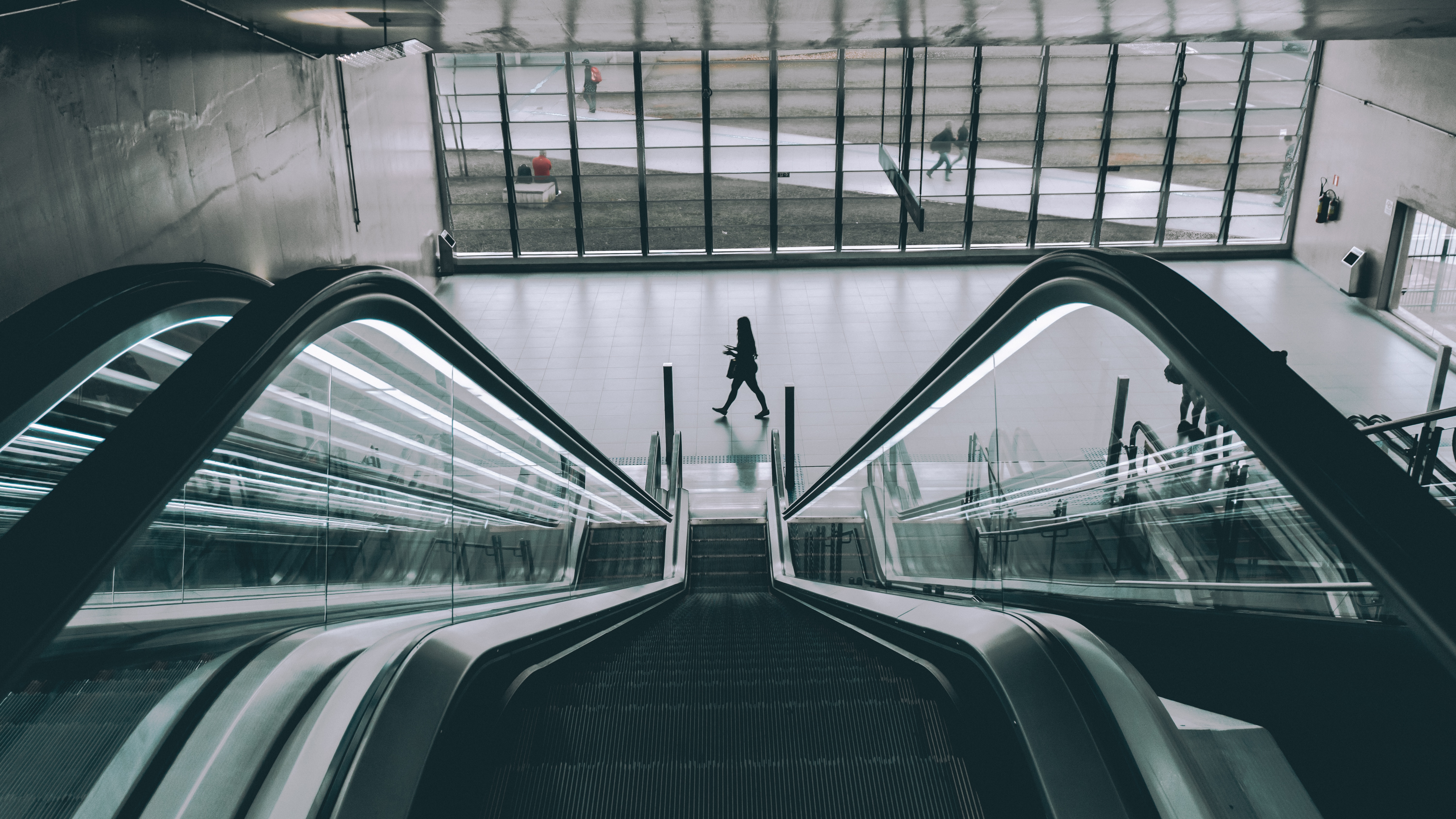person walks towards escalator