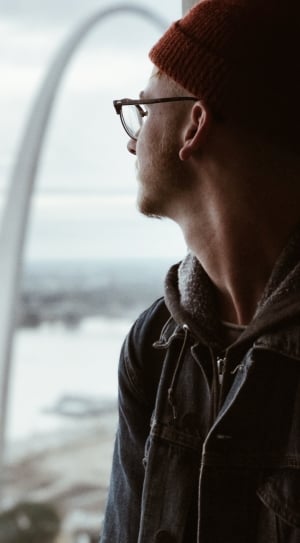 man with eyeglasses and sweatshirt looking on window thumbnail
