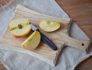 sliced apple beside knife and chopping board thumbnail