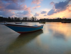 blue boat on body of water during daytime thumbnail