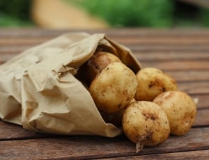 potatoes on brown paper bag above woode platform thumbnail