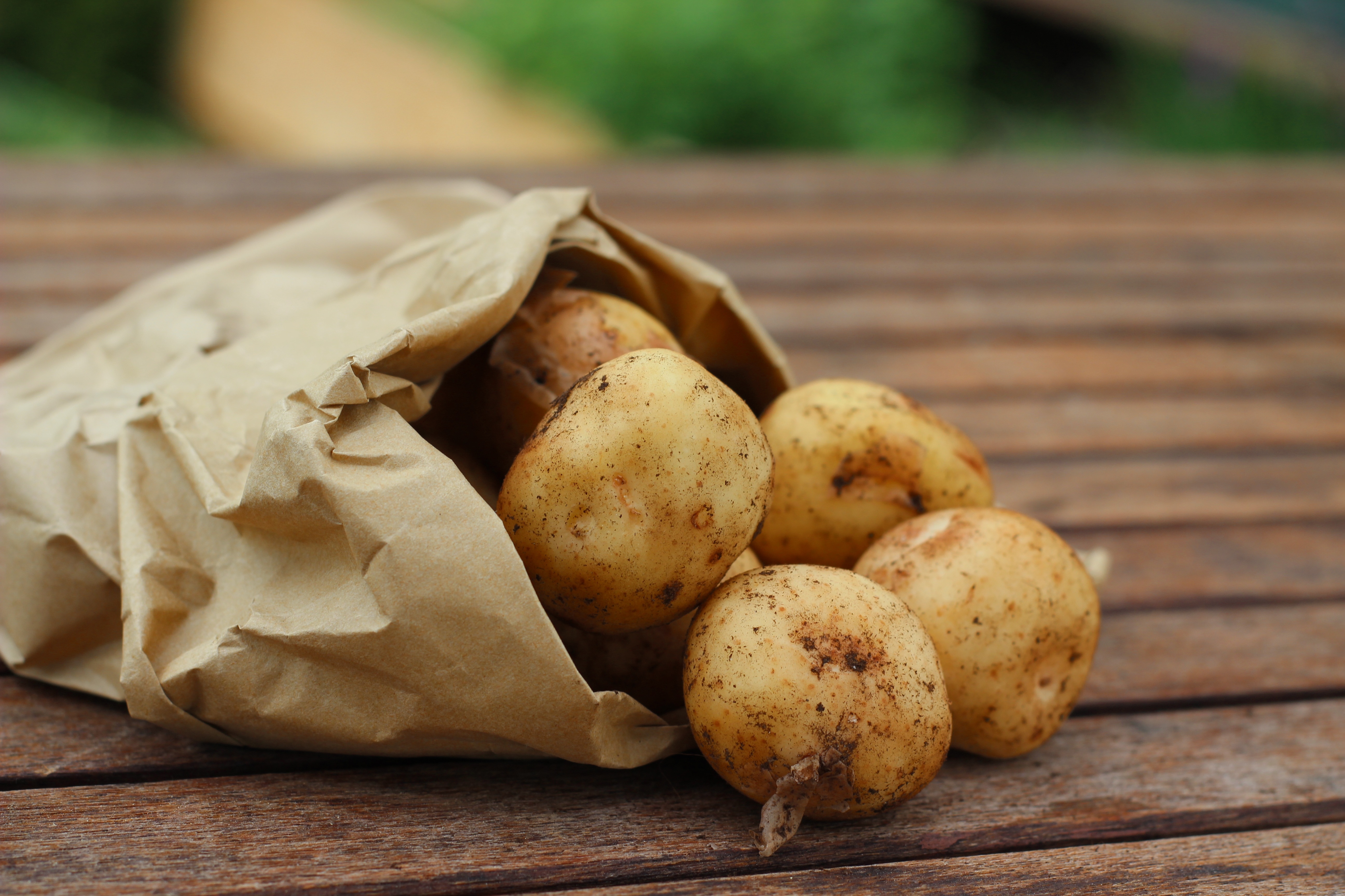 potatoes on brown paper bag above woode platform
