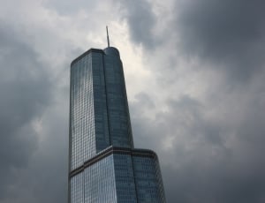 low angle photo of curtain wall high rise building under gray clouds thumbnail