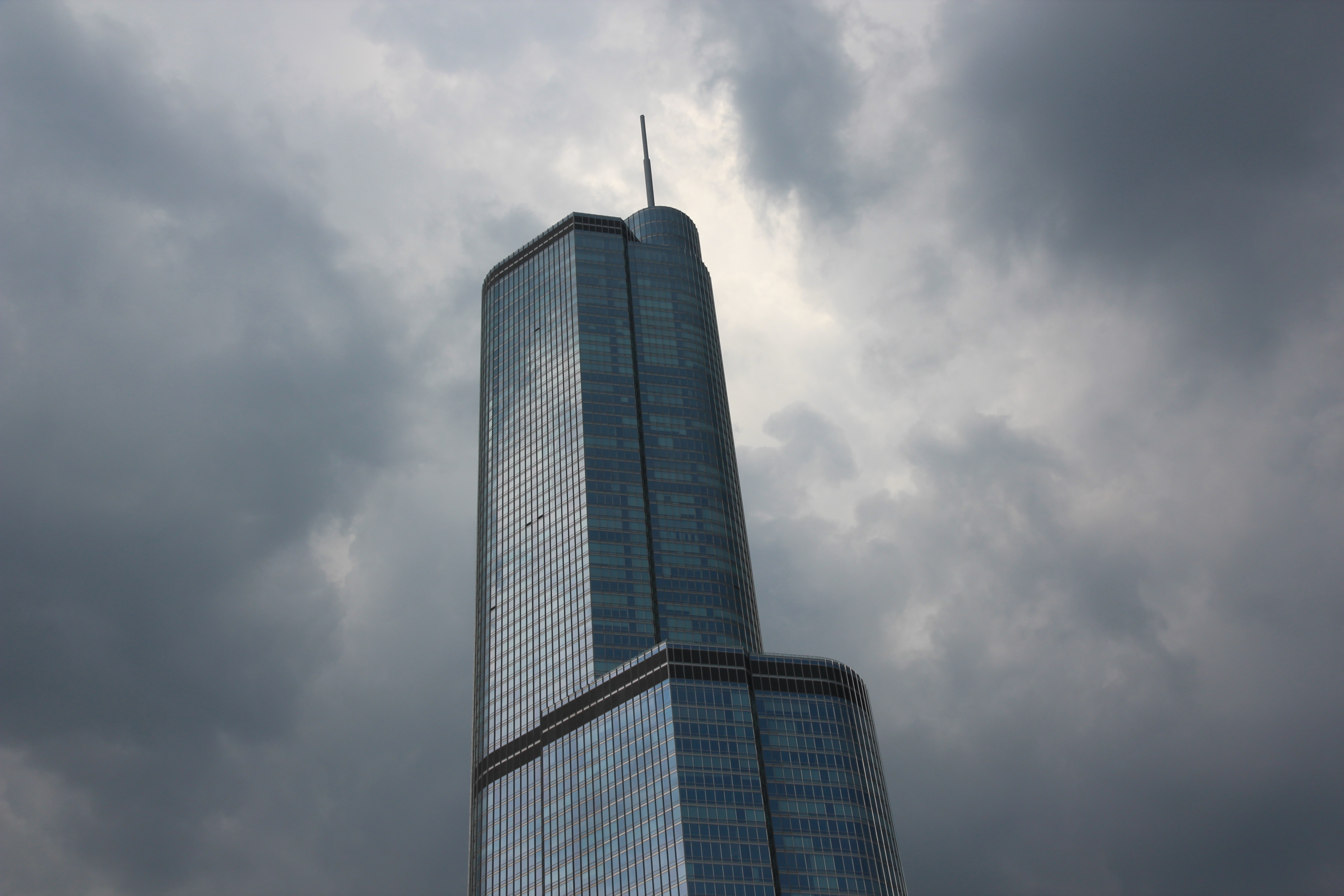 low angle photo of curtain wall high rise building under gray clouds