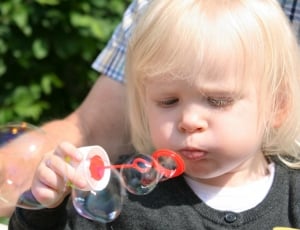 photo of girl holding red blow bubble toy thumbnail