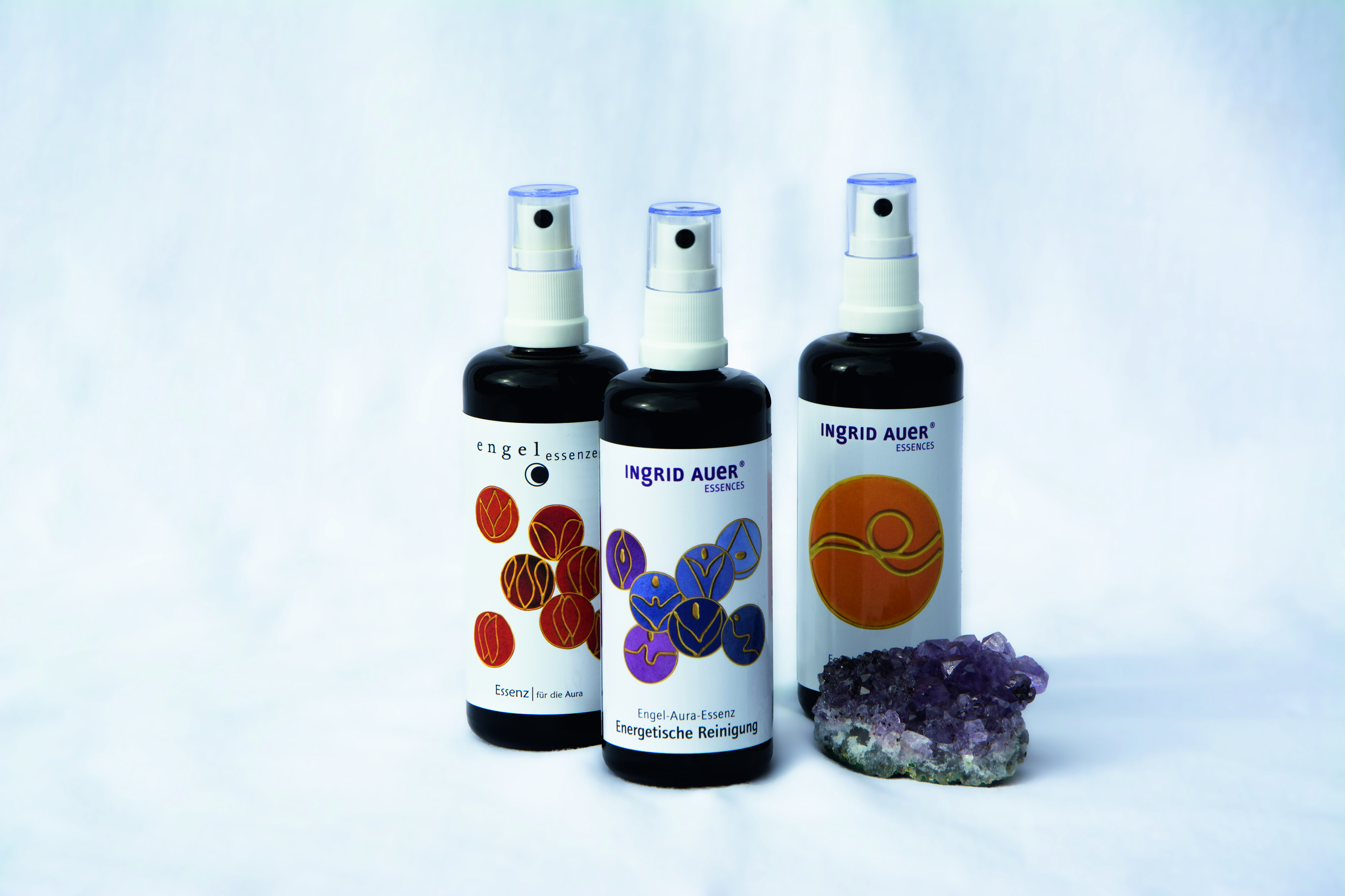 three purple and white labeled spray bottles