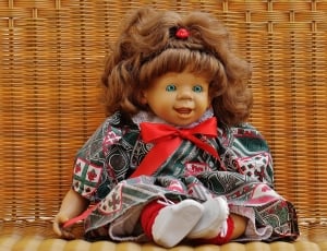 baby porcelain doll in red and green bow dress thumbnail