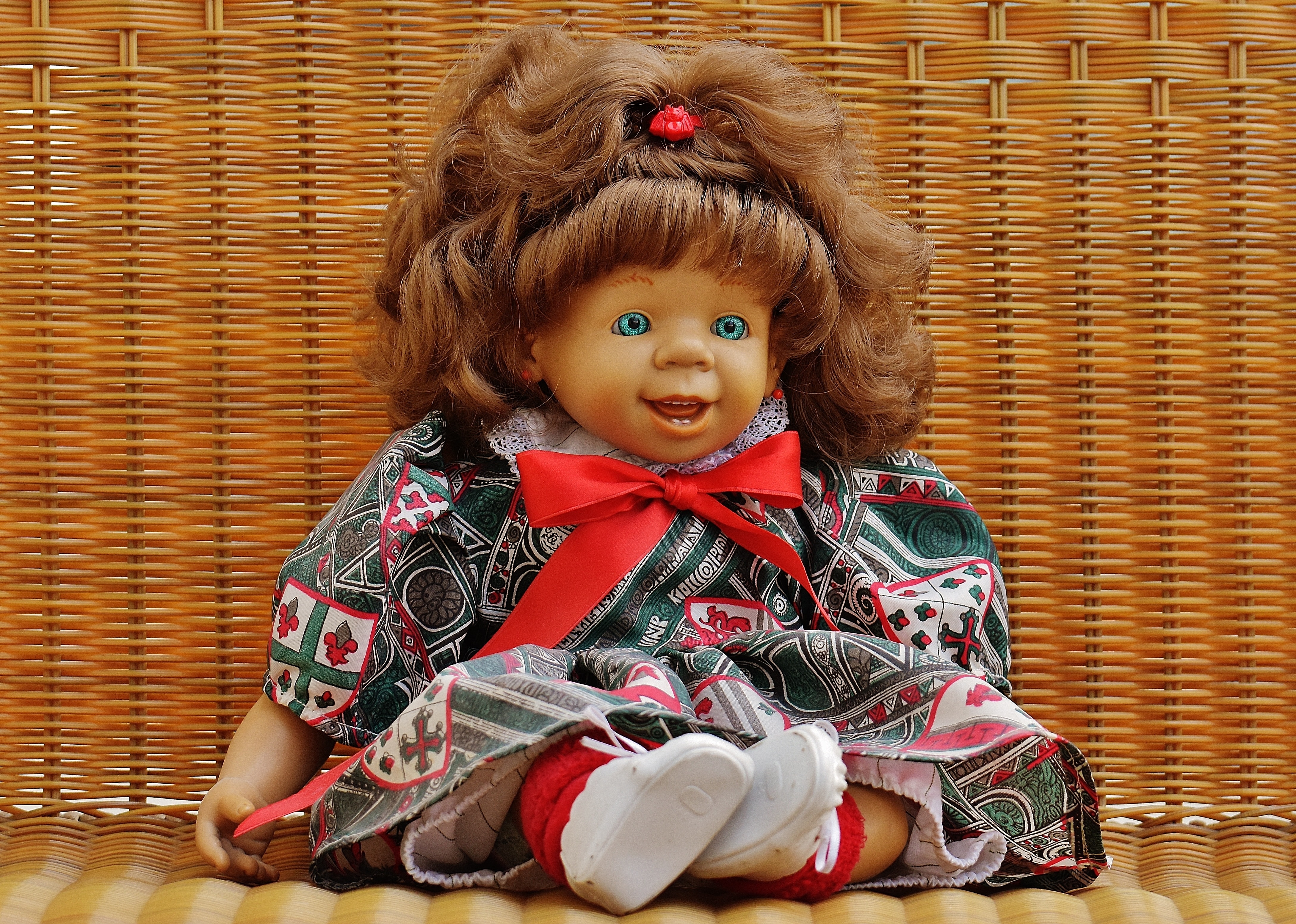 baby porcelain doll in red and green bow dress