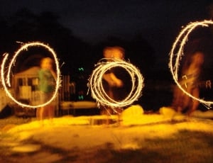 three persons making circular shape with fireworks thumbnail