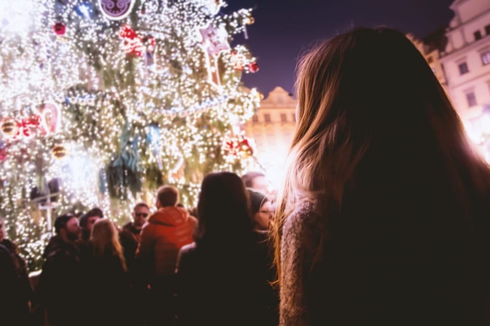 people staring on huge christmas tree with string lights during nighttime preview