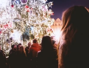 people staring on huge christmas tree with string lights during nighttime thumbnail