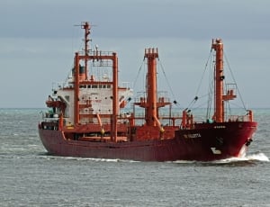 red and white Oil carrier ship on body of water during daytime thumbnail