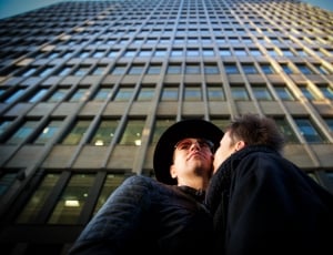 couple kissing near skyscraper during daytime thumbnail