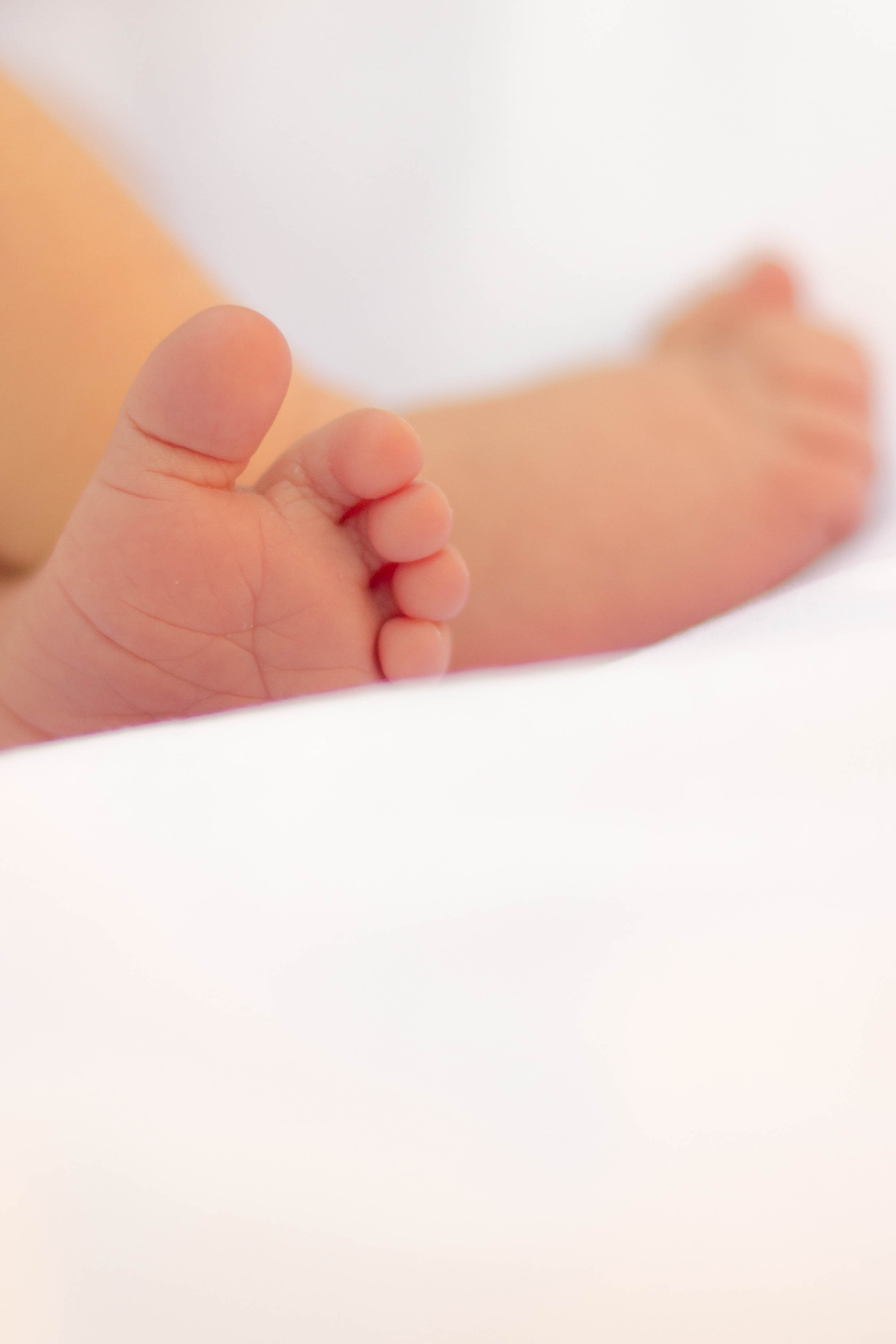 photo showing baby's feet on white textile