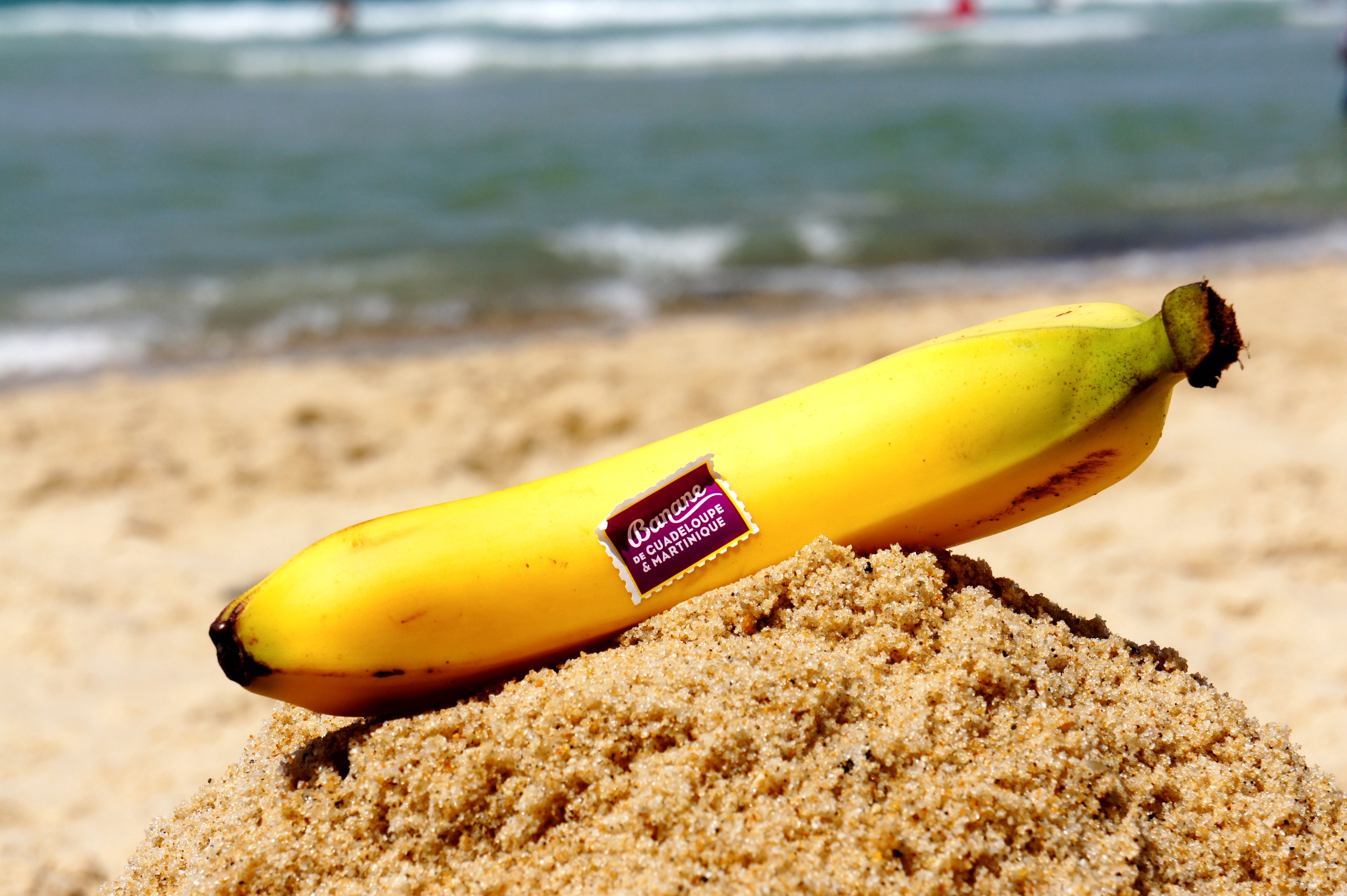 close up photo of yellow banana fruit above white sand