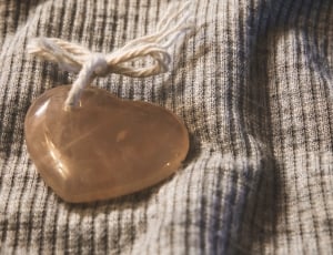 brown heart shape stone on top of gray textile thumbnail
