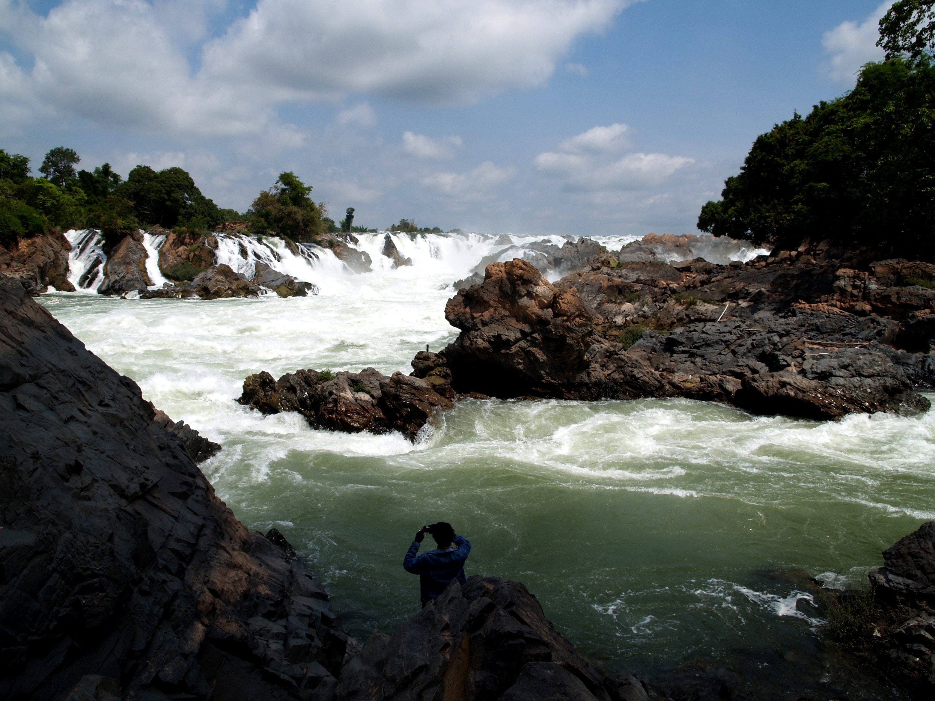 man in long sleeve shirt taking photo of river during daytime