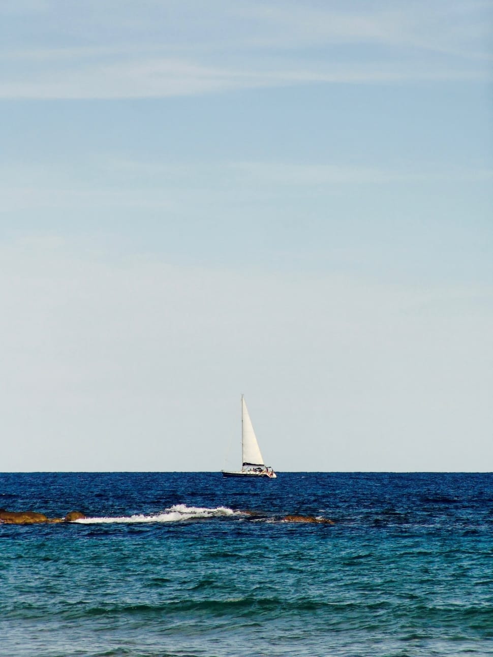 white boat on blue seashore during daytime preview