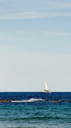 white boat on blue seashore during daytime thumbnail