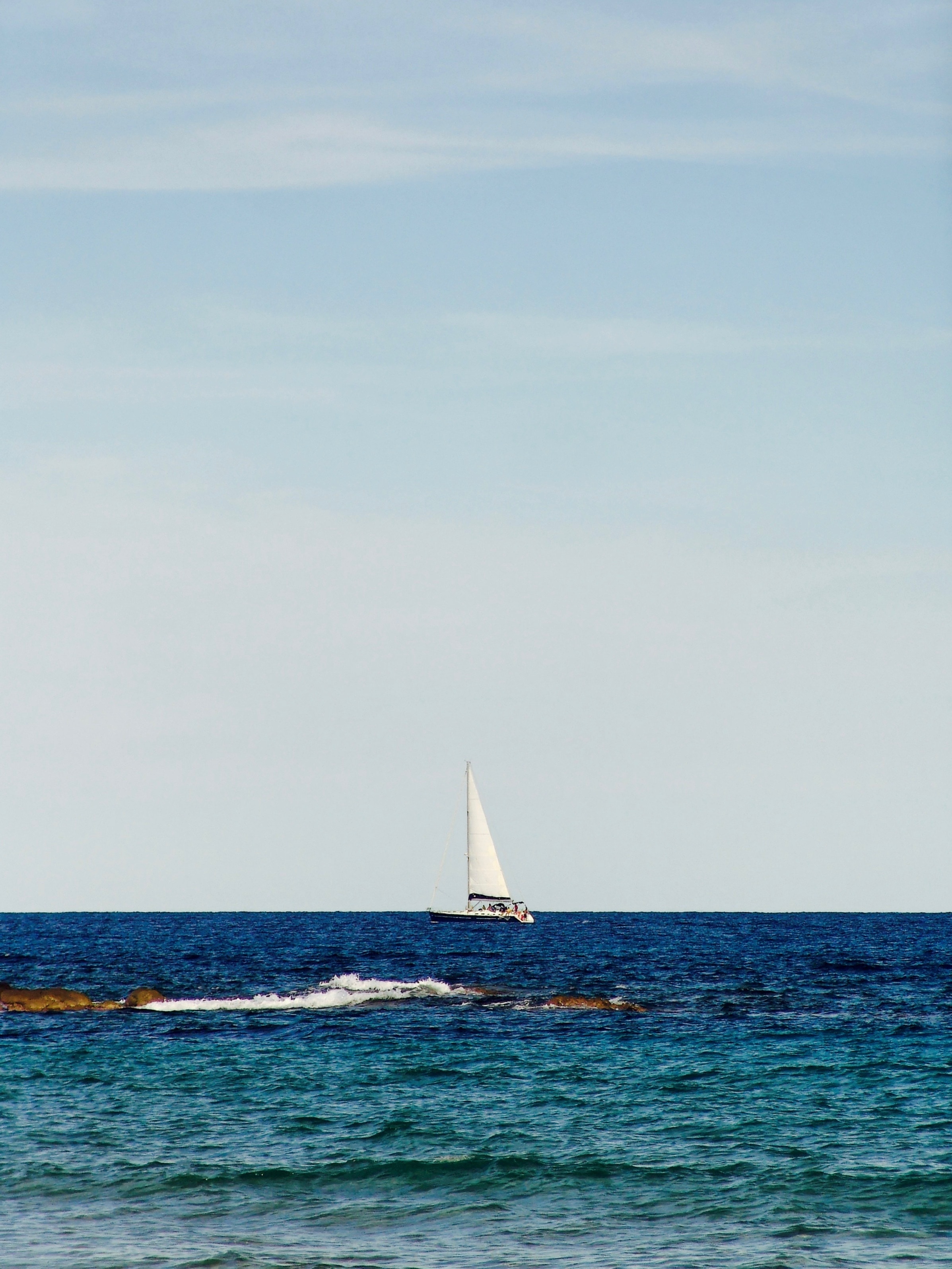 white boat on blue seashore during daytime