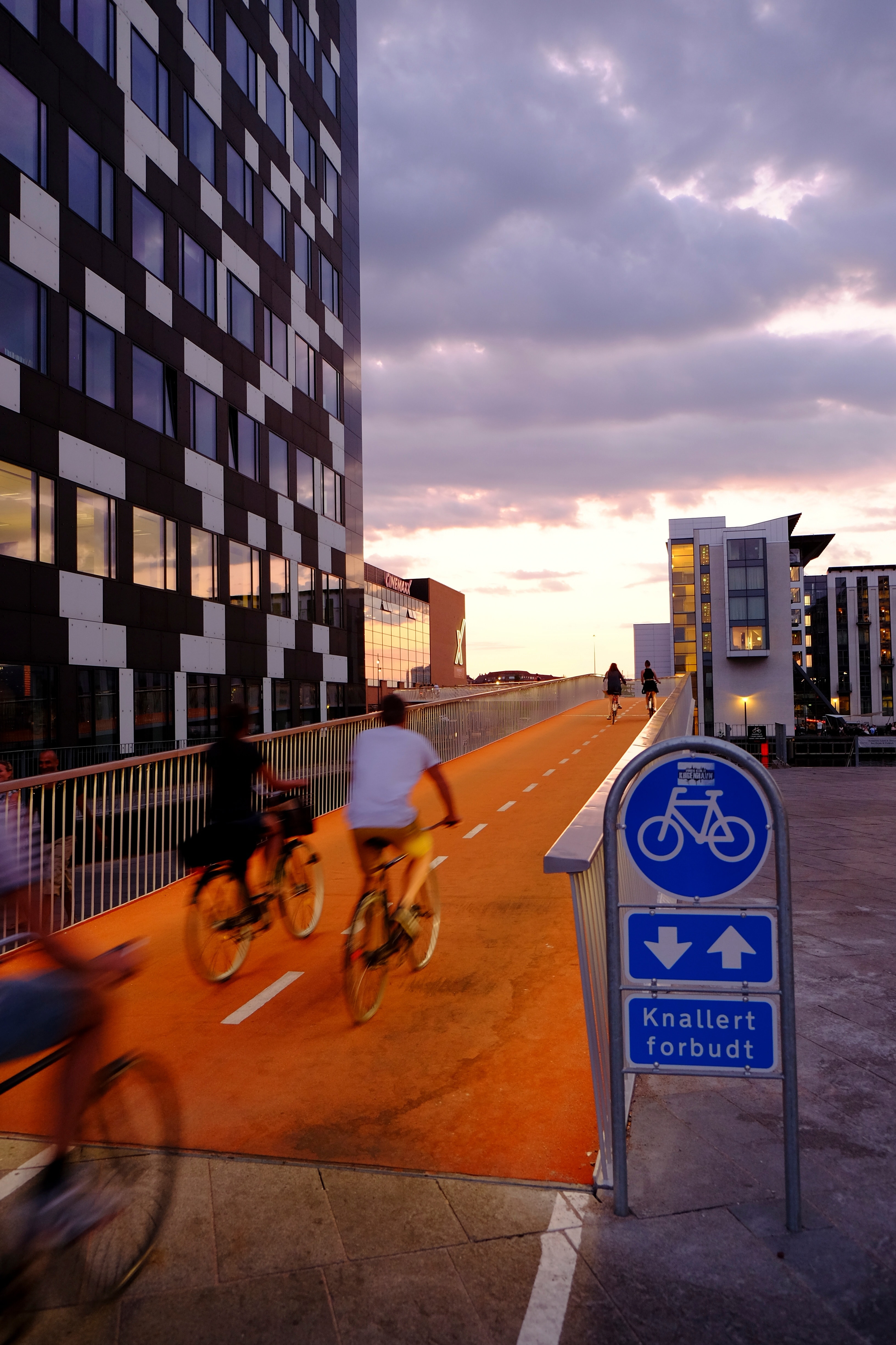 people riding bicycles on orange road