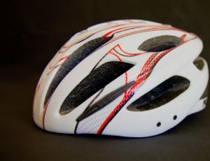 white and red bicycle helmet on a black surface thumbnail