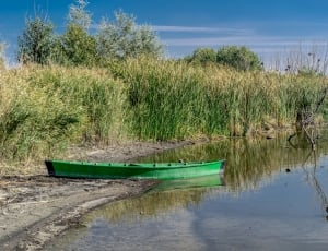 green boat near bodies of water thumbnail