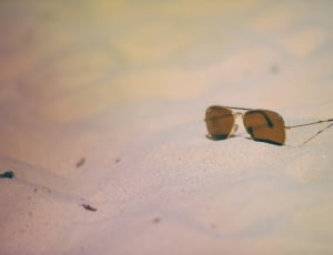 brown aviator sunglasses on white sand thumbnail