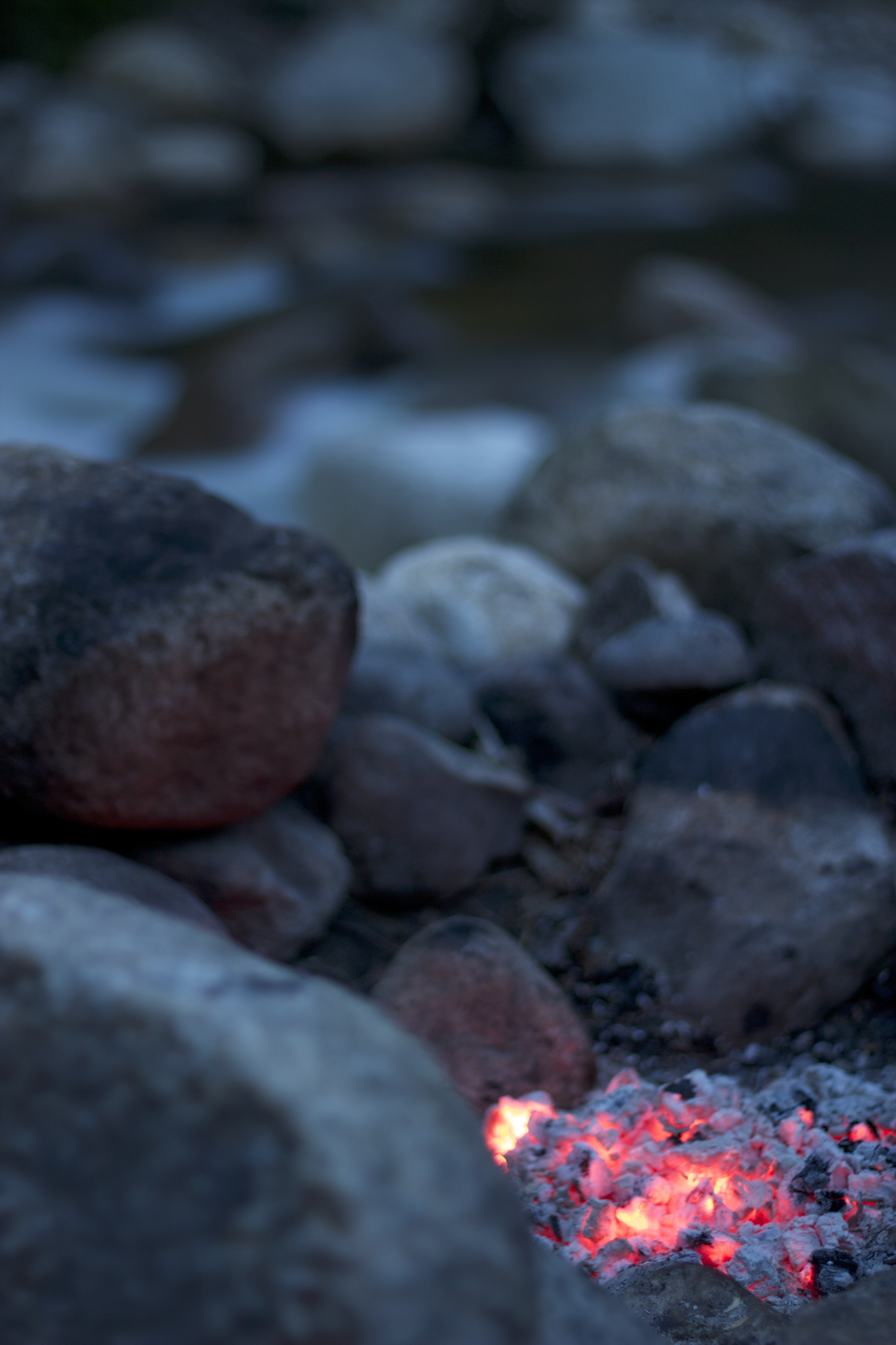 shallow focus photography of burning charcoal near body of water