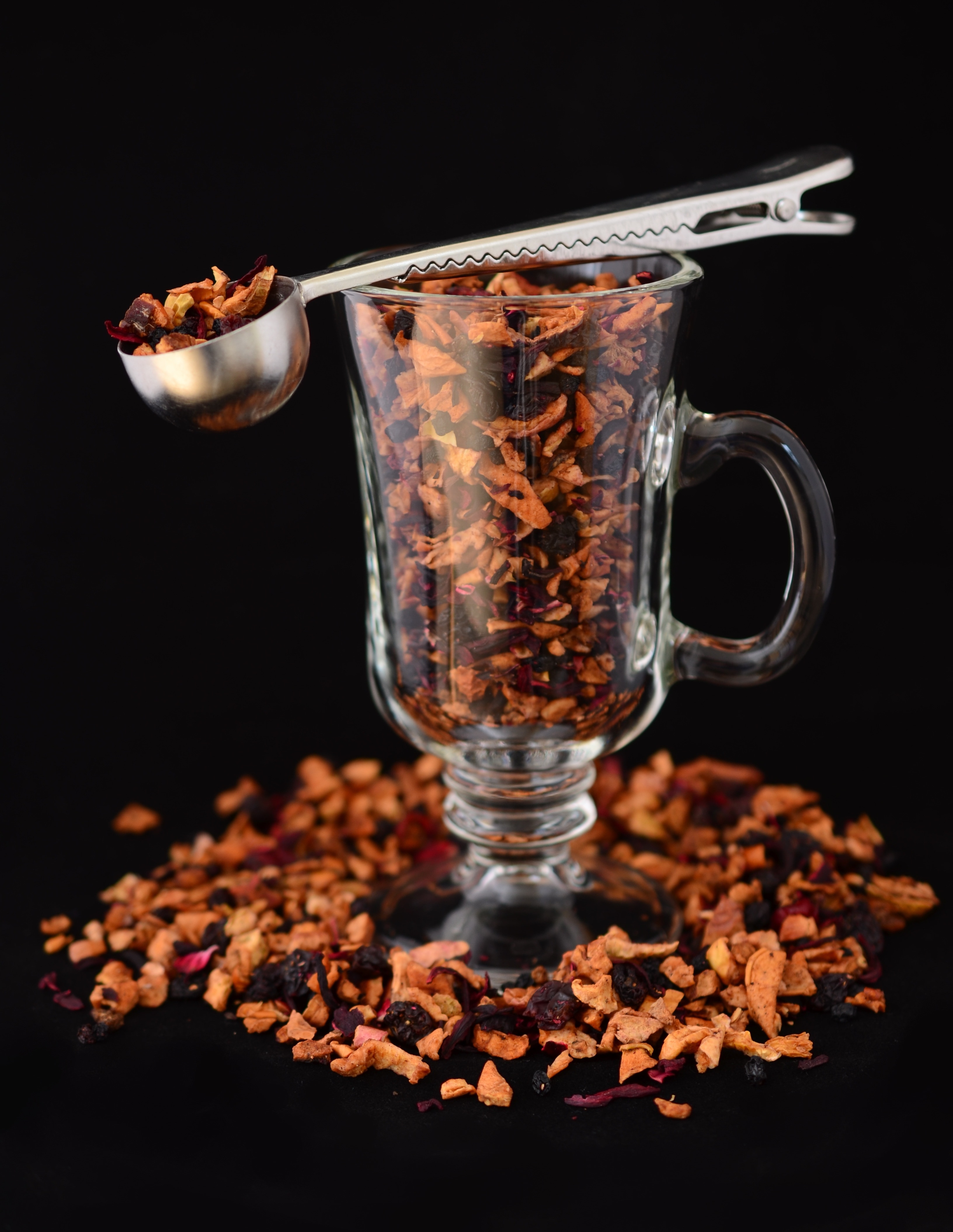 stainless steel scooper and clear glass mug filled with dried fruits
