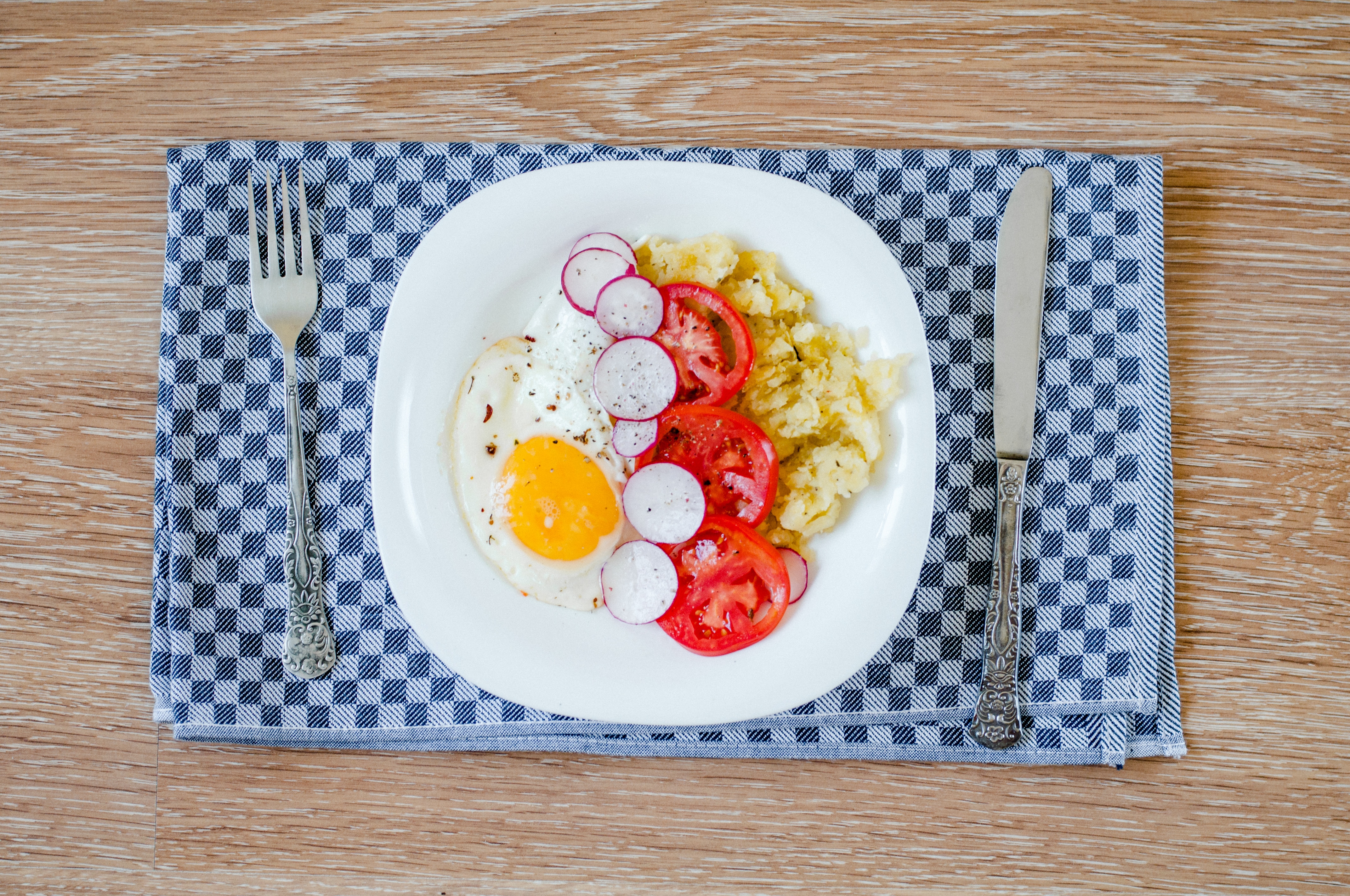 white ceramic plate with egg and vegetables on the table