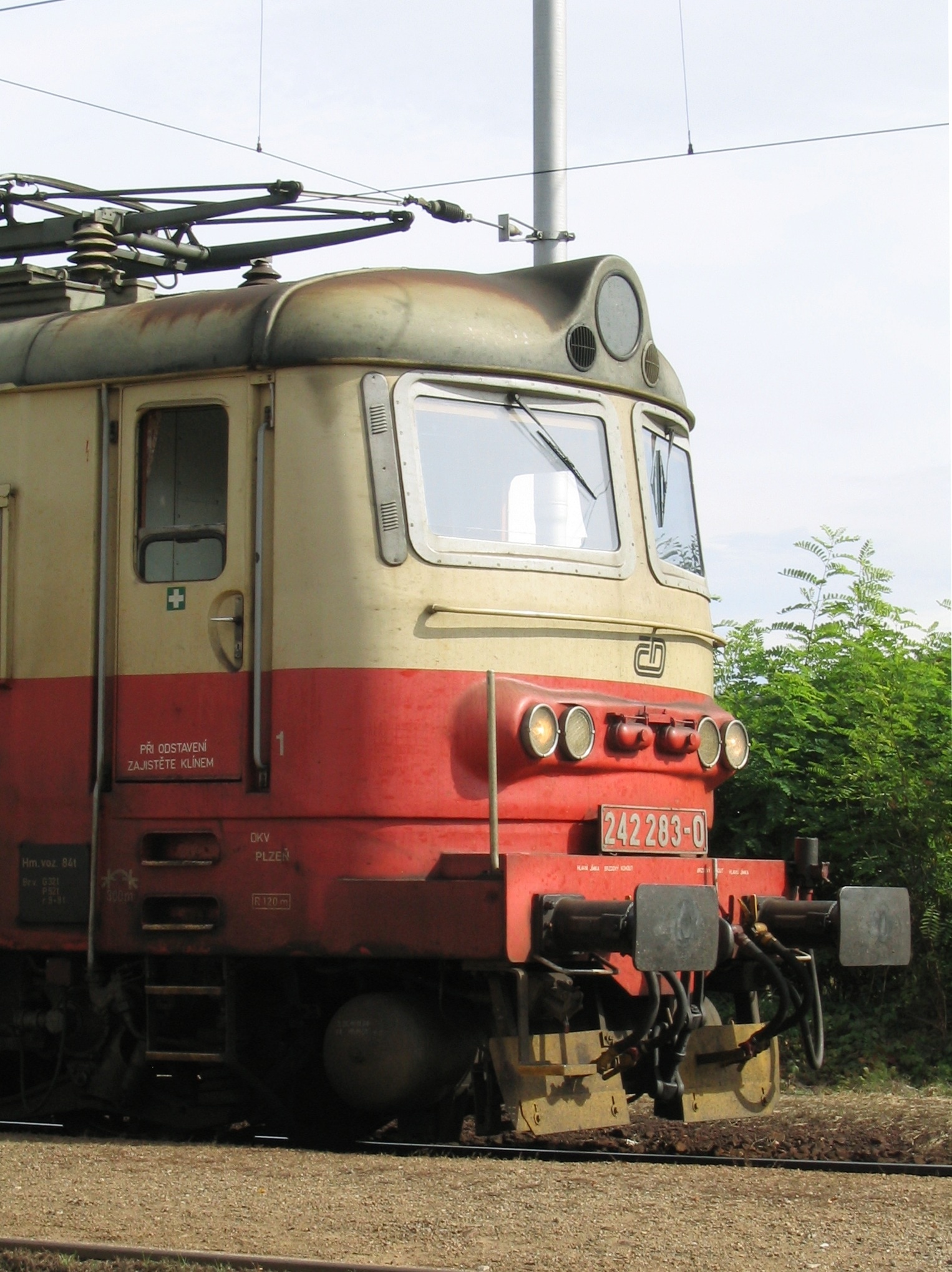 photography of red and beige train with #242 283-0 plate