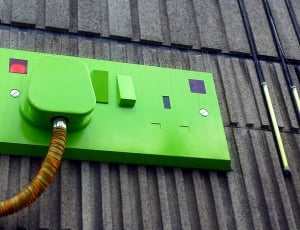 green power switch on gray wall thumbnail