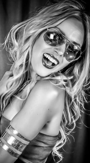 woman wearing gold framed aviator sunglasses while laughing thumbnail