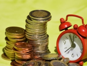 nickel and brass coins collection and red digital desk alarm clock thumbnail