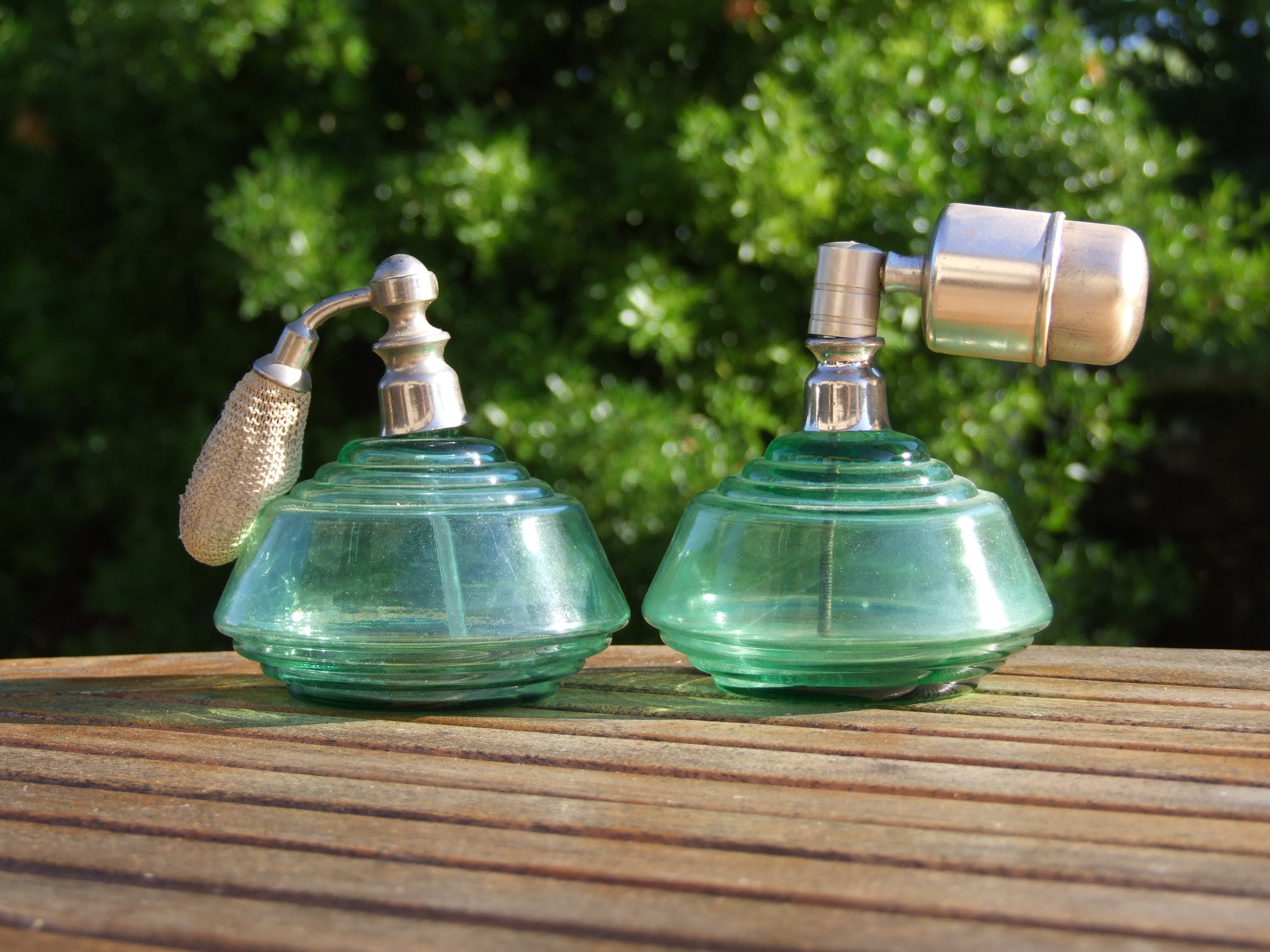 2 green glass and stainless steel spray bottles