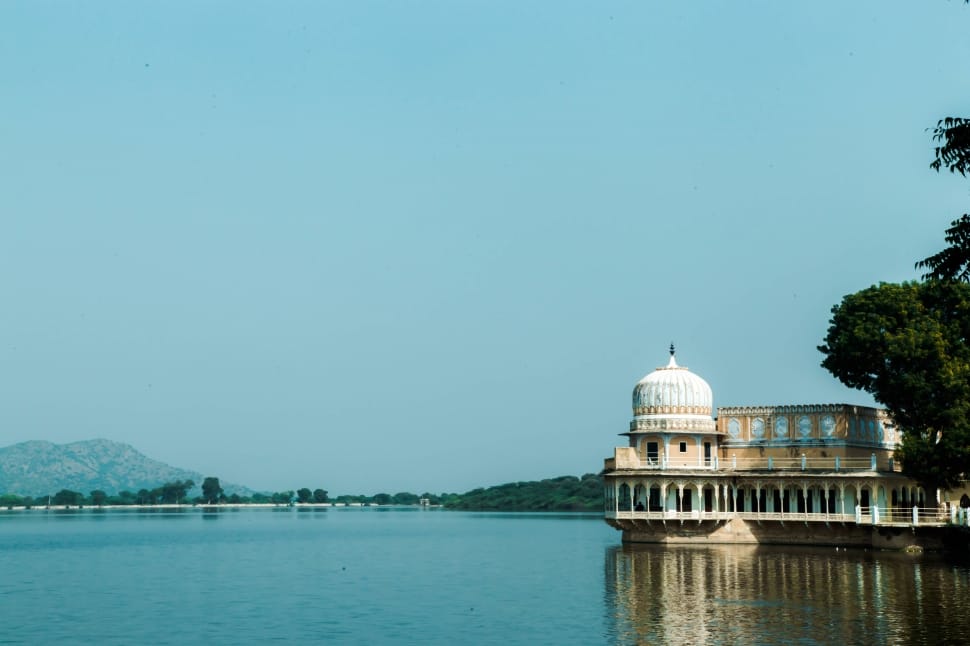 brown concrete mosque near body of water during daytime preview