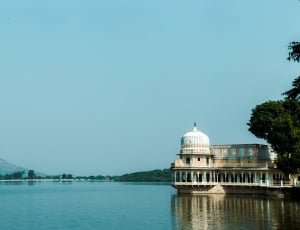 brown concrete mosque near body of water during daytime thumbnail