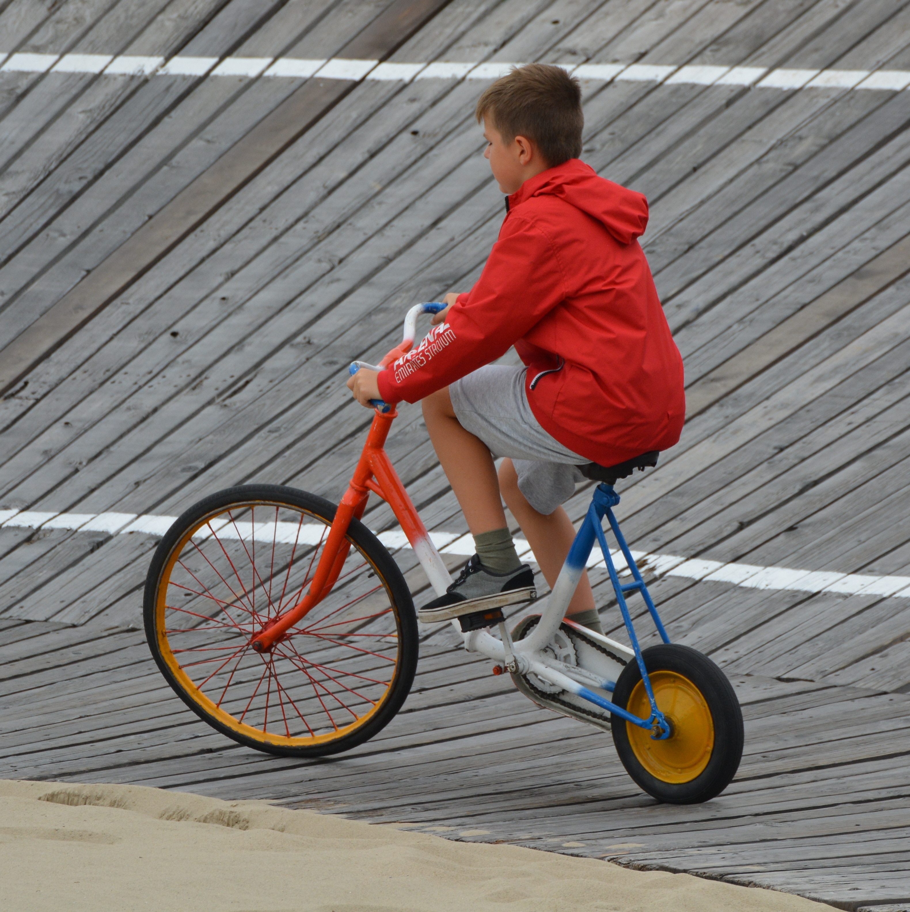 boy's red hooded jacket riding on bicycle at daytime