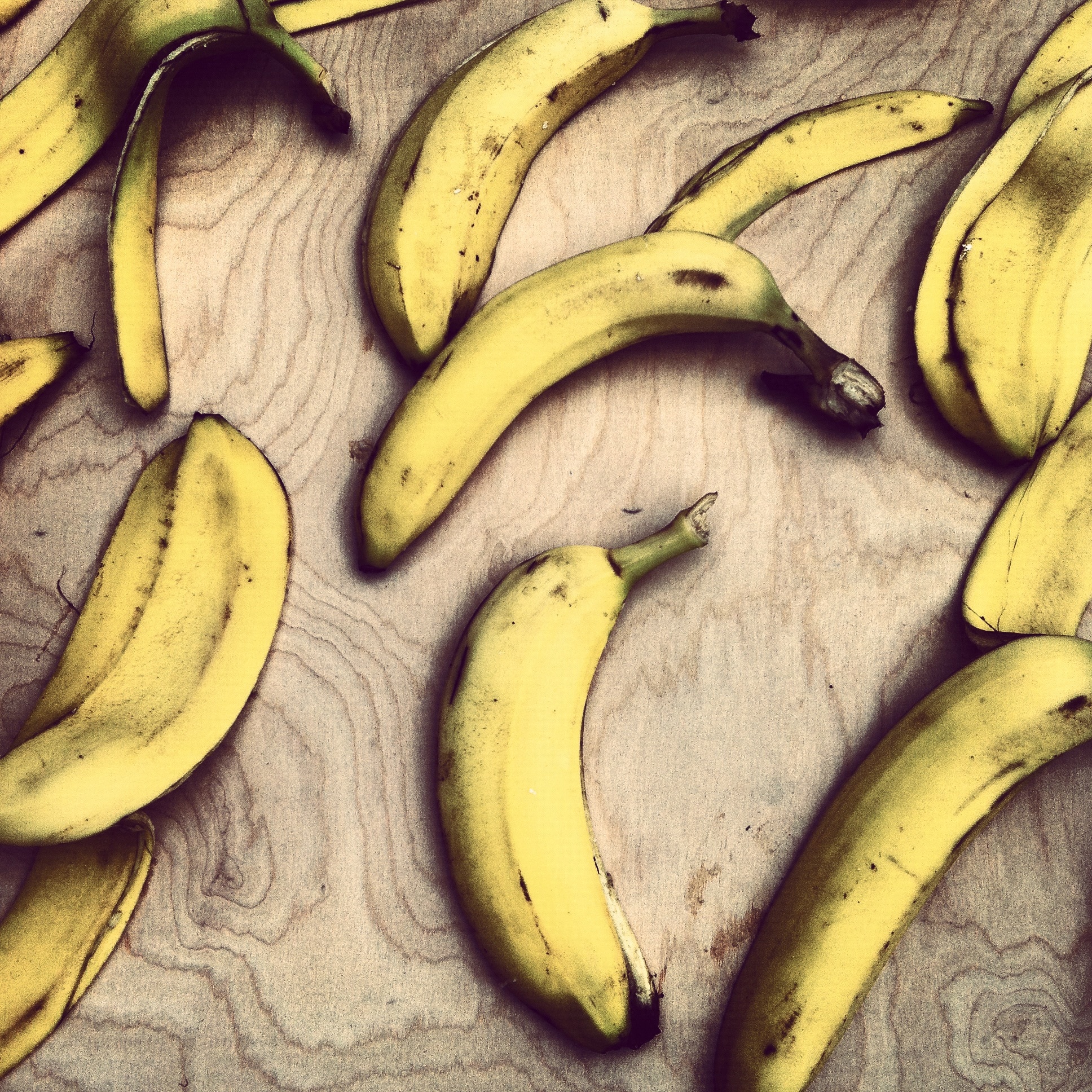 yellow bananas on top of brown wooden surface
