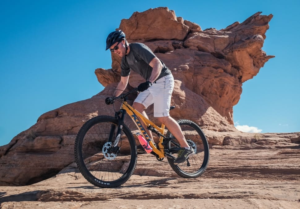 man riding yellow full suspension bike on brown rock mountain preview