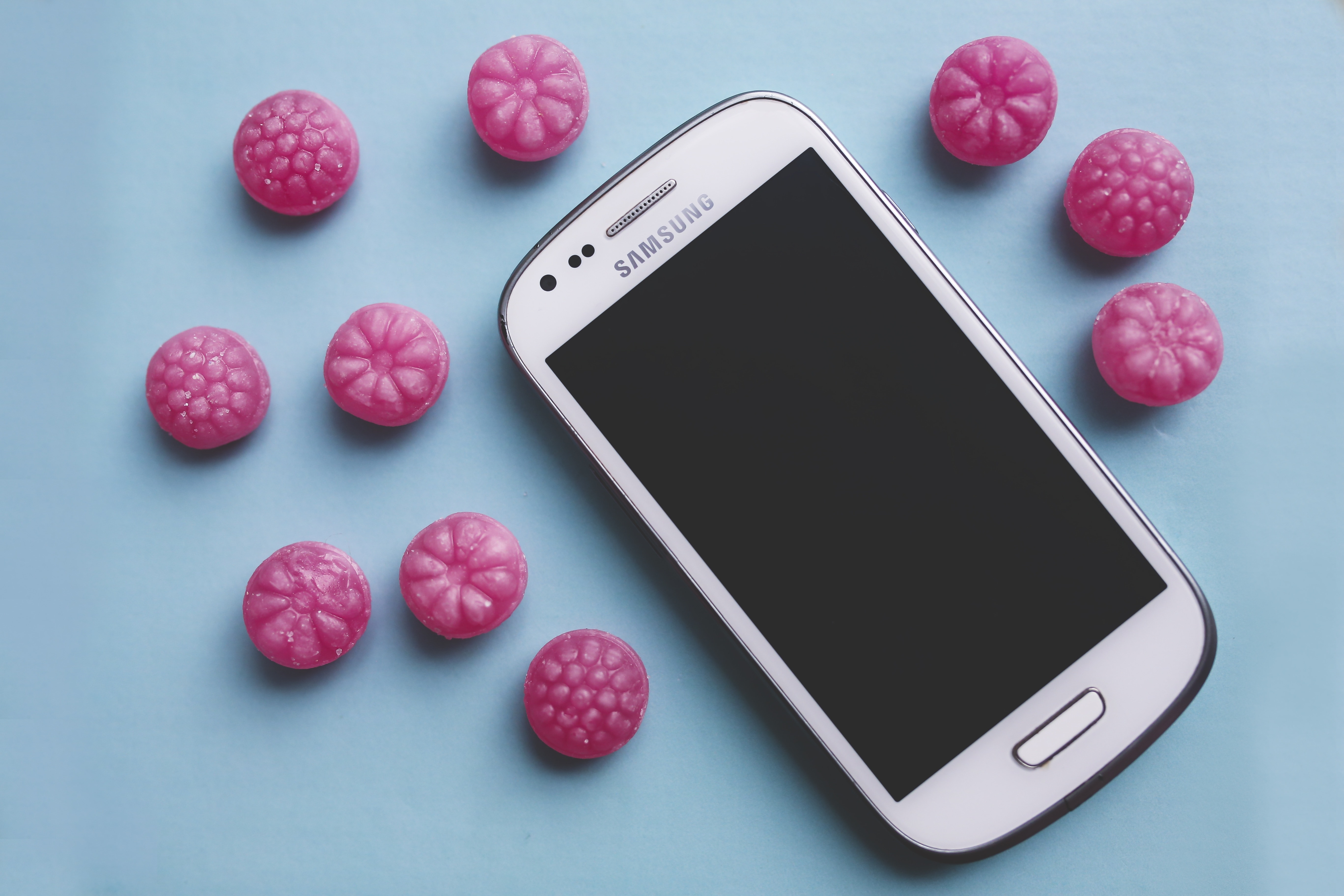 Pink candies and white smartphone
