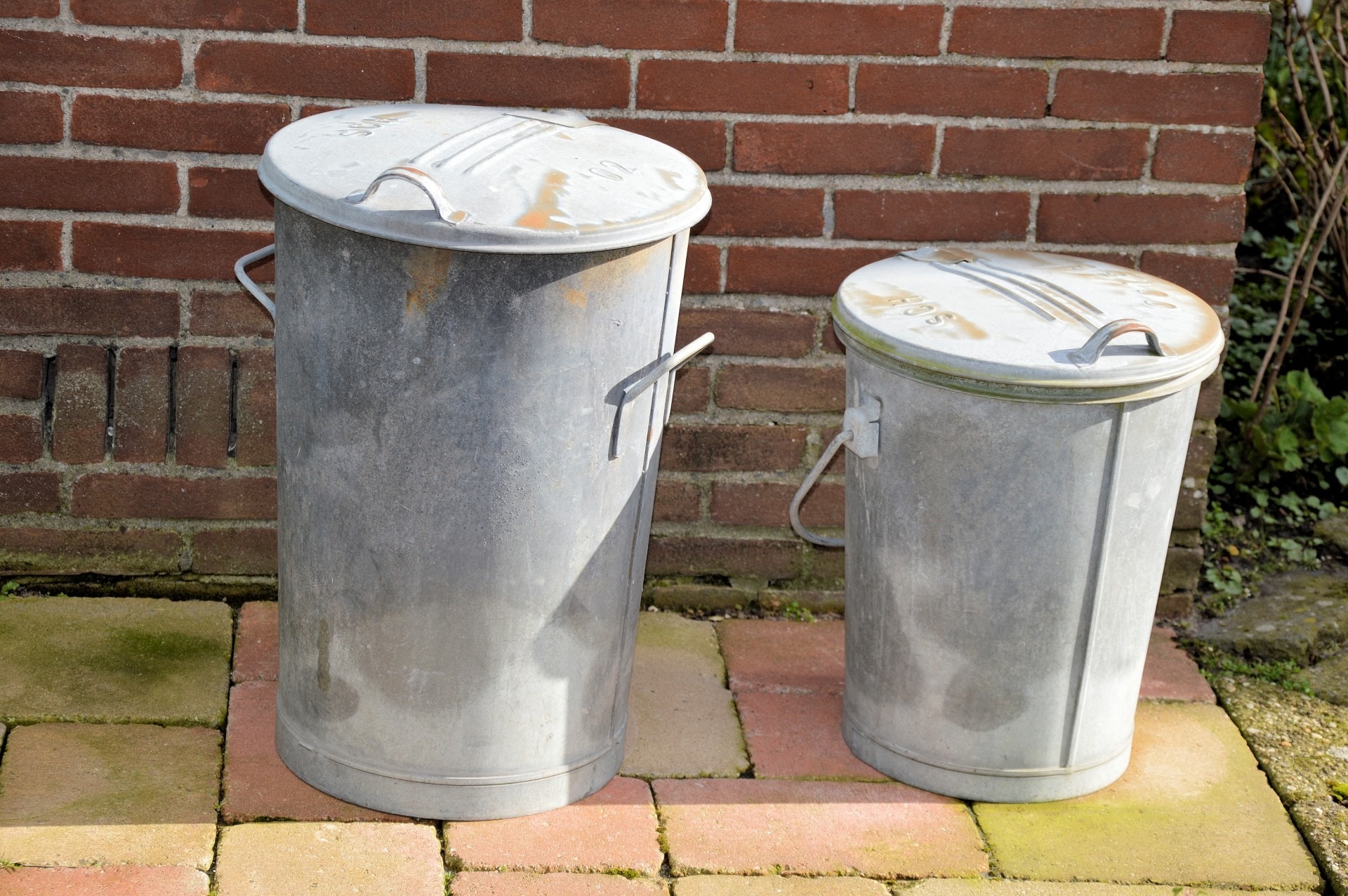 2 grey metal trash bins