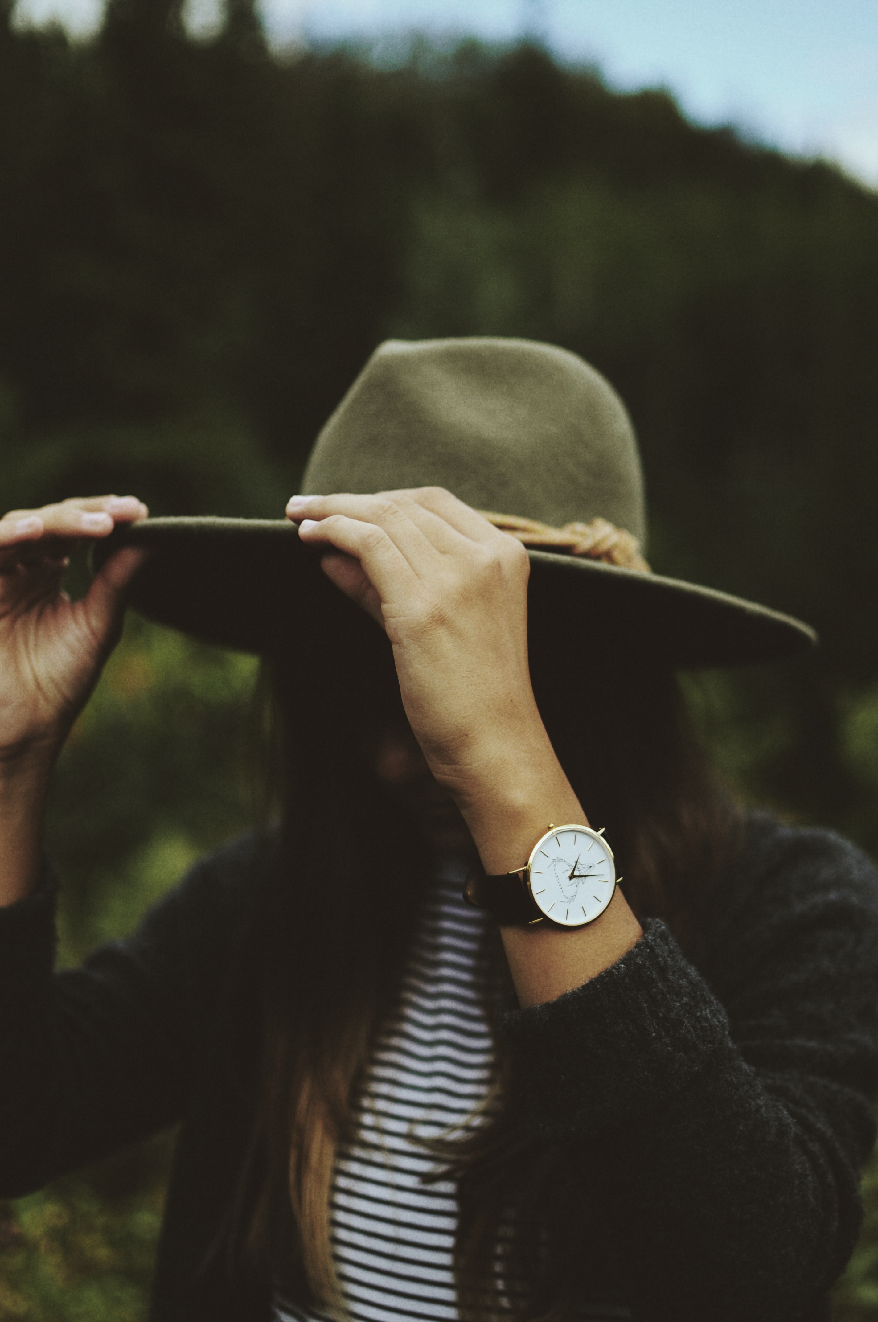 woman with brown hand analog  watch black sweater