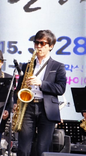 man playing brass saxophone on stage thumbnail