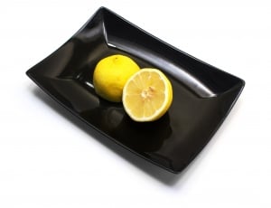black ceramic plate with sliced lemon thumbnail