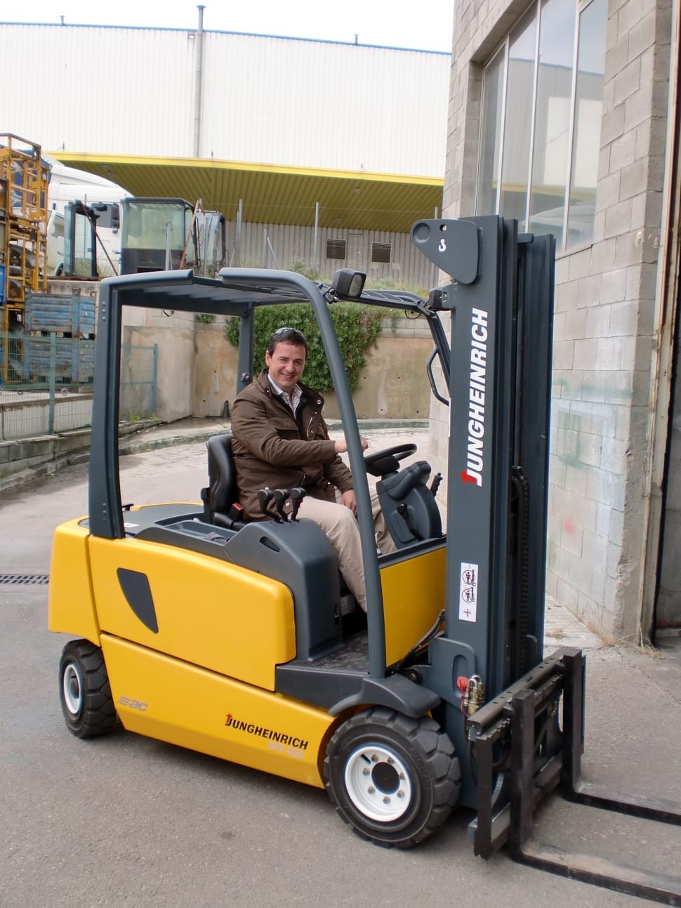 man smiling sitting on black and yellow Jungherich fork lift preview