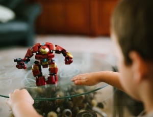 boy facing red and yellow ironman toy thumbnail